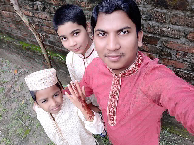 ঈদের দিন মসজিদে যাওয়ার আগ মুহূর্তে প্রতিবেশী ছোট ভাই প্রিরন ও পারভেজের সঙ্গে আতিকুজ্জামান। তিনি রংপুরের বাসিন্দা।