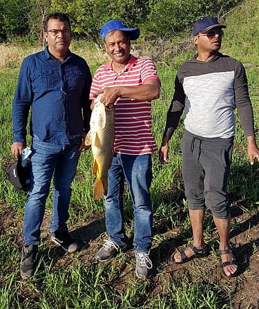 লেখকের সঙ্গে মাছ হাতে আশরাফ ভাই এবং ফয়জুর রাজ্জাক। ছবি: সংগৃহীত