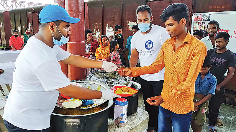 পাঁচ টাকায় দরিদ্রদের মধ্যে খিচুড়ি বিক্রি করছে জামালপুরের স্বেচ্ছাসেবী সংগঠন ‘আমরা ফাউন্ডেশন’ । শুক্রবার দুপুরে জামালপুর রেলওয়ে স্টেশনে। ছবি: প্রথম আলো