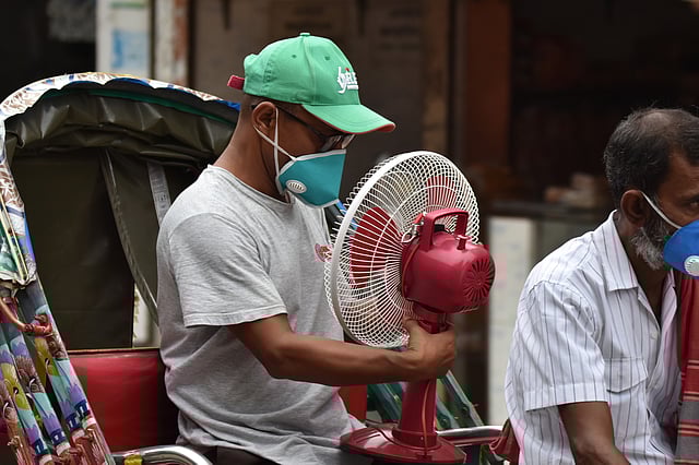 একদিকে প্রচণ্ড গরম, অন্যদিকে বিদ্যুৎ বিভ্রাট। তাই ব্যাটারিচালিত ফ্যান কিনে বাড়ি ফিরছেন এক ব্যক্তি। আব্দুল হামিদ সড়ক, পাবনা, ১০ জুন। ছবি: হাসান মাহমুদ