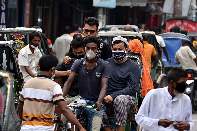 এক রিকশায় উঠেছেন তিন যাত্রী। তাঁদের একজনের নেই মাস্ক। আব্দুল হামিদ সড়ক, পাবনা, ১০ জুন। ছবি: হাসান মাহমুদ