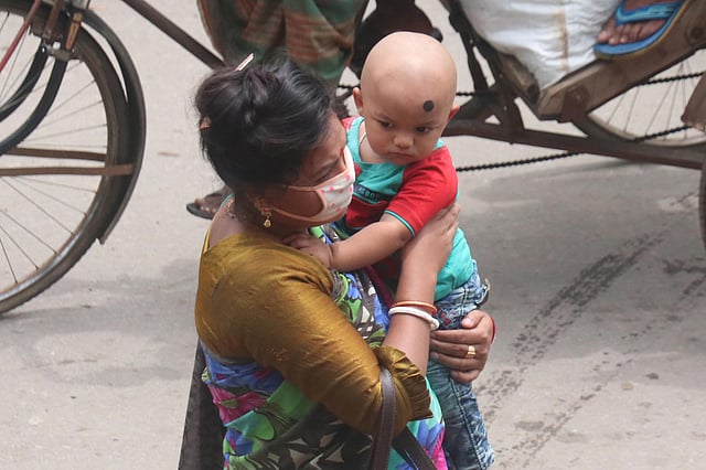 করোনাভাইরাস সংক্রমণের ঝুঁকিরে মধ্যে শিশুকে কোলে নিয়ে নগরে এসেছেন এক নারী। নিজের মুখে মাস্ক থাকলেও শিশুর সুরক্ষায় নেই সচেতনতা। কোর্টপয়েন্ট, সিলেট, ১০ জুন। ছবি: আনিস মাহমুদ