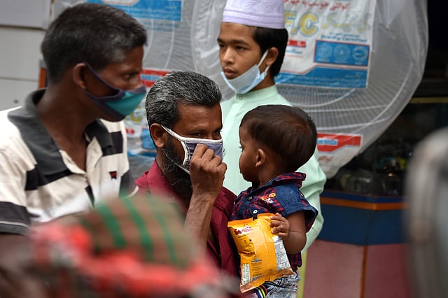 অনেকেই সঠিক নিয়মে মাস্ক পরেন না। আবার সুরক্ষা ছাড়া শিশুদের নিয়ে অভিভাবকেরা বাইরে আসায় সংক্রমণের ঝুঁকি থাকছে। আব্দুল হামিদ সড়ক, পাবনা, ১০ জুন। ছবি: হাসান মাহমুদ
