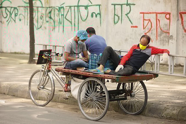 করোনাভাইরাসের সংক্রমণের মধ্যেও ঝুঁকি নিয়ে কাজে নেমেছে ঢাকা উত্তর সিটি করপোরেশনের কর্মীর। রাস্তার নষ্ট বাতি মেরামতের পর ক্লান্ত হয়ে ঘুমিয়ে পড়েছেন এক বিদ্যুৎকর্মী। ঢাকা বিশ্ববিদ্যালয়, ১০ জুন। ছবি: আশরাফুল আলম