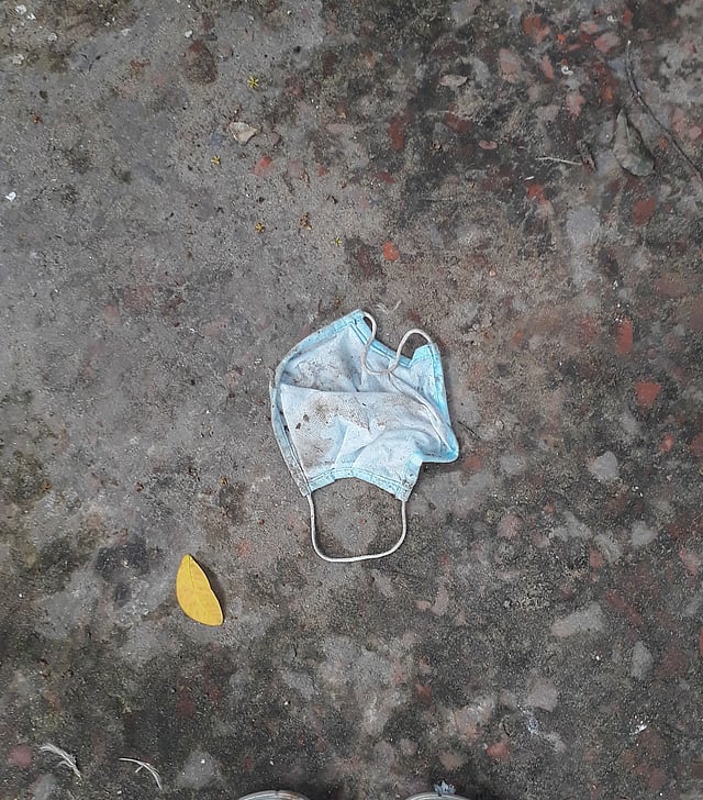 সিমেন্ট-বাঁধানো স্থানে পরিত্যক্ত মাস্ক