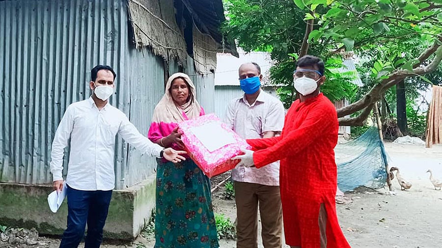 নেত্রকোনার কেন্দুয়ায় কোভিড–১৯ রোগীদের বাড়িতে ফলের প্যাকেট নিয়ে হাজির করোনাজয়ী ইউএনও আল-ইমরান রুহুল ইসলাম (লাল পাঞ্জাবি পরা)। গত বুধবার রাত থেকে গতকাল বৃহস্পতিবার রাত পর্যন্ত ৬২ জনকে উপহার হিসেবে ফল দেওয়া হয়। ছবি: প্রথম আলো