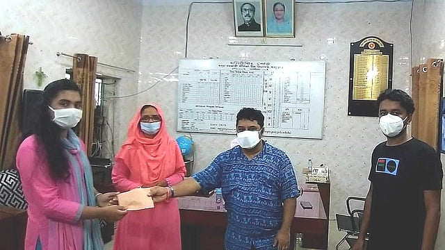 মুশফিকুর রহিমের পক্ষ থেকে কলেজে ভর্তি ও বইকেনার টাকা তাইরিনা সাবরিনার হাতে তুলে দেওয়া হচ্ছে। আজ শনিবার বগুড়ার সরকারি বালিকা উচ্চ বিদ্যালয়ের প্রধান শিক্ষকের কক্ষে। ছবি: প্রথম আলো