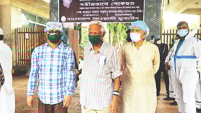 করোনা আক্রান্ত হয়ে মারা যাওয়া সাবেক স্বাস্থ্যমন্ত্রী ও আওয়ামী লীগ নেতা মোহাম্মদ নাসিমকে শ্রদ্ধা জানাতে সদ্য করোনাজয়ী ডা. জাফরুল্লাহ চৌধুরী (মাঝে)। এ সময় তাঁকে মরদেহের সামনে যেতে দুজন সহায়তা করেন। গতকাল বনানী কবরস্থানে।  ছবি: সংগৃহীত