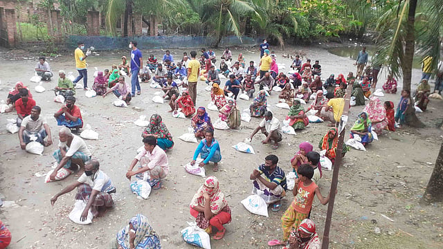 ১৫ জুন সোমবার দুপুরে প্রথম আলো ট্রাস্টের উদ্যোগে বুড়িগোয়ালিনী ইউনিয়নের দাতিনাখালি সরকারি প্রাথমিক বিদ্যালয়ের মাঠে ১৫৫টি অসহায় পরিবারকে খাদ্যসহায়তা দেওয়া হয়। ছবি: প্রথম আলো