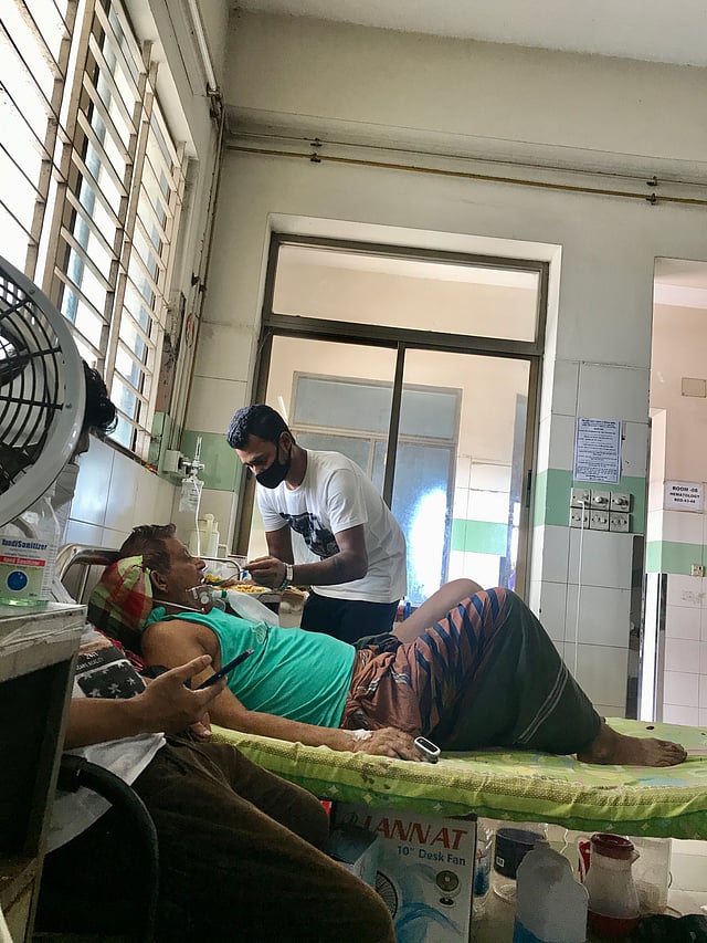 বাবাকে দুপুরের খাবার খাওয়াচ্ছেন ছোট ছেলে মোস্তাক। ছবি: লেখক