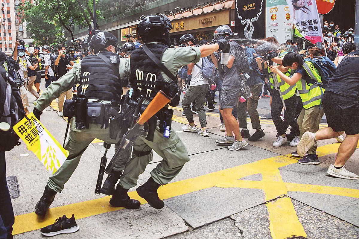 হংকংয়ে নতুন জাতীয় নিরাপত্তা আইনের প্রতিবাদে বিক্ষোভ সমাবেশে জড়ো হন শত শত মানুষ। সেই বিক্ষোভের ছবি তুলতে যাওয়া সাংবাদিকদের মুখে পেপার স্প্রে ছোড়ে দাঙ্গা পুলিশ। গতকাল হংকংয়ের কেন্দ্রস্থলের একটি সড়কে। ছবি: এএফপি