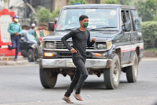 জীবনের ঝুঁকি নিয়ে চলন্ত যানের সামনে দিয়ে দৌড়ে রাস্তা পার হচ্ছেন পথচারী। কাজী নজরুল ইসলাম অ্যাভিনিউ, বাংলামোটর, ঢাকা, ২ জুলাই। ছবি: সাইফুল ইসলাম