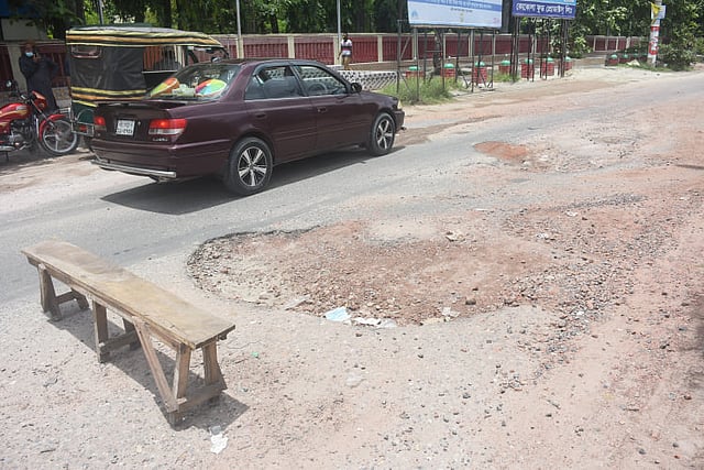 সড়কে গর্ত আছে। আছে ভাঙাচোরা। দুর্ঘটনা এড়াতে ঝুঁকিপূর্ণ স্থানে বেঞ্চ পাতা হয়েছে। খুলনা মেডিকেল কলেজ হাসপাতালের সামনে, সোনাডাঙ্গা-নতুন রাস্তা সড়ক, খুলনা, ৩ জুলাই। ছবি: সাদ্দাম হোসেন
