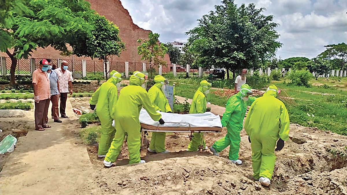 করোনায় মৃত এক নারীর দাফন করছে কোয়ান্টাম ফাউন্ডেশনের নারী স্বেচ্ছাসেবী দল। সম্প্রতি রাজধানীর রায়েরবাজার কবরস্থানে।  ছবি: সংগৃহীত