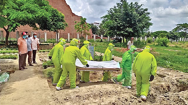 করোনায় মৃত এক নারীর দাফন করছে কোয়ান্টাম ফাউন্ডেশনের নারী স্বেচ্ছাসেবী দল। সম্প্রতি রাজধানীর রায়েরবাজার কবরস্থানে।  ছবি: সংগৃহীত