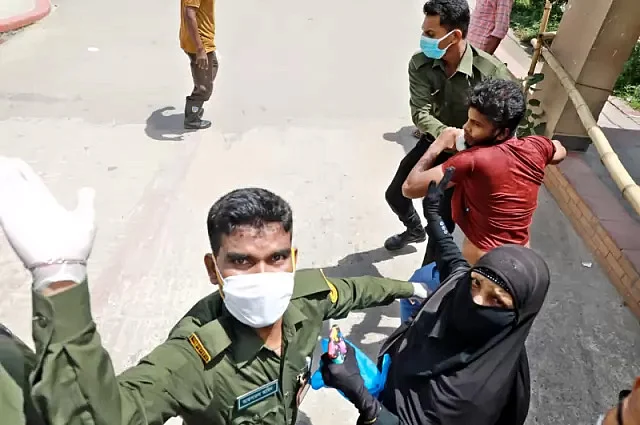 মুগদা জেনারেল হাসপাতালে ক্যানসারে আক্রান্ত মাকে নিয়ে করোনা পরীক্ষা করাতে আসেন ছেলে শাওন। পরীক্ষা তো করাতে পারেননি, উল্টো আনসার সদস্যদের মারধরের শিকার হয়েছেন তিনি। ছবি: সংগৃহীত