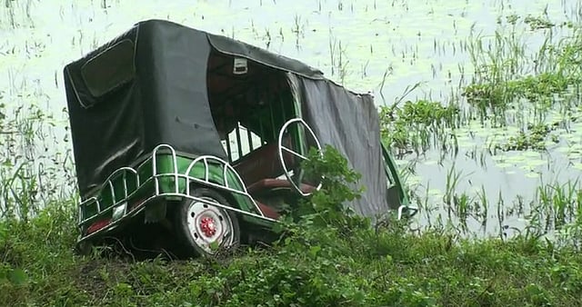যাত্রীবাহী বাসের ধাক্কায় মহাসড়কের পাশের খাদে পড়ে যাওয়া ইজিবাইক। আজ রোববার সকাল সাড়ে নয়টায় ঢাকা-খুলনা মহাসড়কের গোপালগঞ্জ সদর উপজেলার হরিদাসপুর নিমতলা এলাকায়। ছবি: প্রথম আলো