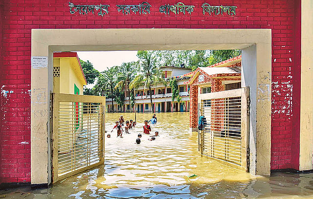 স্কুলের মাঠে বন্যার পানি। সেখানে খেলায় মেতেছে শিশু-কিশোরেরা। রোববার গাইবান্ধার ফুলছড়ি উপজেলার সৈয়দপুর সরকারি প্রাথমিক বিদ্যালয়ে।  ছবি: শাহাবুল শাহীন