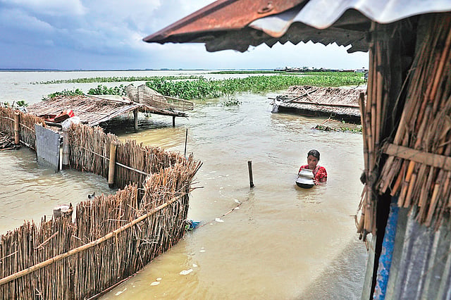 বন‌্যার পানির তোড়ে ঘর ডুবে গেছে শেফালী বেগমের। সেখান থেকে ঘরের তৈজসপত্র নিয়ে অন্যত্র যাচ্ছেন তিনি। রোববার টাঙ্গাইলের ভূঞাপুর উপ‌জেলার চরাঞ্চল গাবসারা ইউনিয়‌নের রাজাপুর এলাকায়।  ছবি: দীপু মালাকার