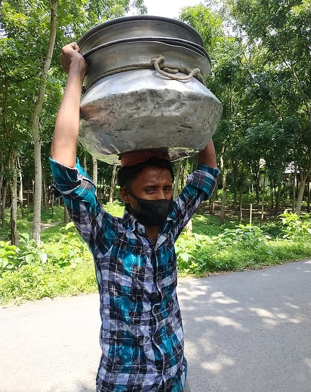 মাথায় পাতিলে করে মাছ বিক্রি করছেন মনিরুল ইসলাম। ছবি: প্রথম আলো
