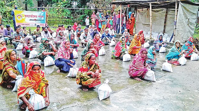 প্রথম আলো ট্রাস্টের উদ্যোগে সুনামগঞ্জে বন্যার্তদের মধ্যে ত্রাণ বিতরণ করে বন্ধুসভা। বৃহস্পতিবার দুপুরে জেলার দোয়ারাবাজার উপজেলার ইসলামপুর গ্রামে। ছবি: প্রথম আলো
