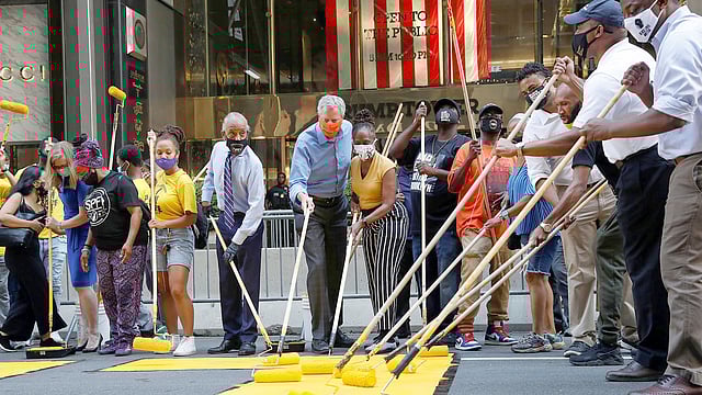 ট্রাম্প টাওয়ারের সামনের সড়কে ‘ব্ল্যাক লাইভস মেটার’-এ রঙ দিচ্ছেন নিউইয়র্ক নগরের মেয়র বিল ডি ব্লাজিও, তাঁর স্ত্রী চার্লেইন আইরিন ম্যাকক্রে ও নাগরিক আন্দোলনের নেতা আল শার্পটন। ছবি: রয়টার্স
