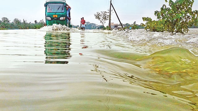 উজানের পানিতে আবারও ভেসেছে সুনামগঞ্জ। সুরমা নদীর পানি সড়ক পেরিয়ে হাওরে ঢুকছে। গতকাল দুপুরে জামালগঞ্জ উপজেলা সড়কের জগাইরগাঁও এলাকায়।  ছবি: খলিল রহমান