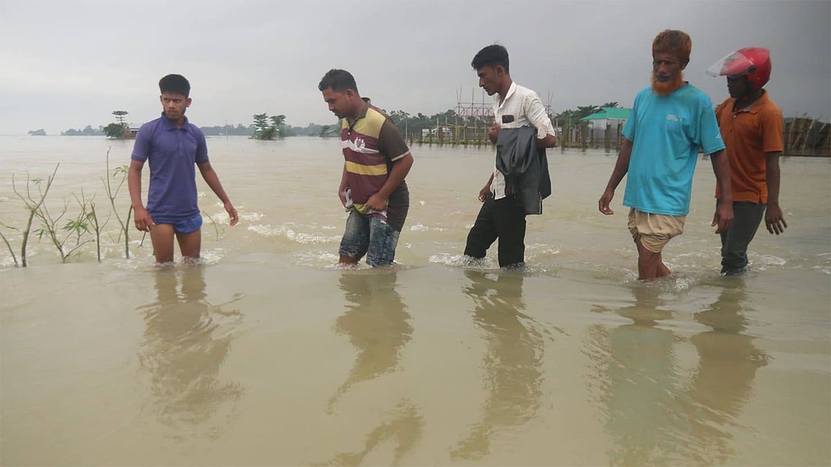 গত পাঁচ দিনের টানা বৃষ্টি ও উজান থেকে নেমে আসা পাহাড়ি ঢলে সুনামগঞ্জ জেলার প্রায় সব কটি উপজেলা গত শুক্রবার থেকে বন্যাকবলিত হয়ে পড়ে। তলিয়ে গেছে সড়ক। ঝুঁকি নিয়ে চলছেন মানুষ। রাধানগর, সদর, সুনামগঞ্জ, ১৩ জুলাই। ছবি: আনিস মাহমুদ