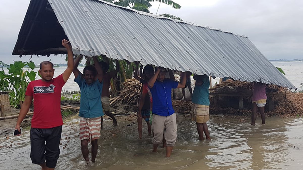 তিস্তা নদীর বন্যায় নীলফামারীর ডিমলার বিভিন্ন গ্রামে বিলীন হচ্ছে বসতঘর ও আবাদি জমি। অনেকে ভাঙনের মুখে তাদের বসতঘর সরিয়ে নিচ্ছেন। রোববার দুপুরে উপজেলার টেপাখড়িবাড়ি ইউনিয়নের টাপুর চর গ্রামে। ছবি: প্রথম আলো