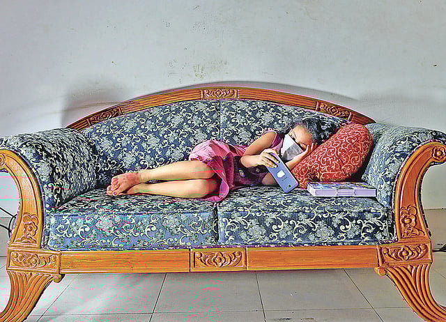 ঘরবন্দী শিশুরা অবসাদ কমাতে টিভি-মোবাইলে সময় কাটাচ্ছে এখন। চট্টগ্রাম নগরে বসবাস করা সত্যি দাশ মোবাইলে ভিডিও দেখছে। শনিবার বিকেলে চট্টগ্রাম নগরের রহমতগঞ্জ এলাকায়।  সৌরভ দাশ