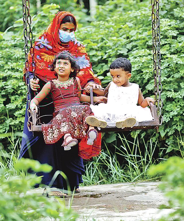 অবসাদ কাটাতে শিশু ফারিয়া মণি ও সাবিহা মণিকে নিয়ে বেড়াতে বেরিয়েছেন মা। গত শনিবার রাজধানীর কাওলার আমবাগান শিশুপার্কে।  ছবি: তানভীর আহাম্মেদ