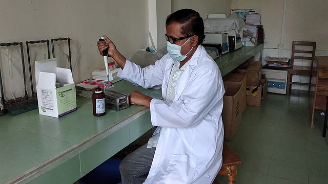 শরীয়তপুর সদর হাসপাতালের প্যাথলজি ল্যাবে কাজ করছেন মেডিকেল টেকনোলজিস্ট আসলাম মিয়া। ছবি: প্রথম আলো