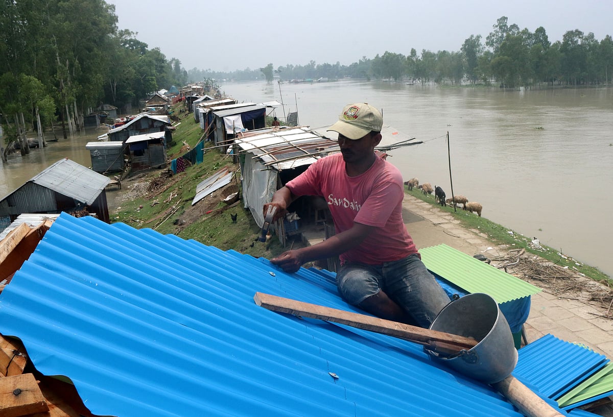 বাড়িঘর পানিতে ডুবে যাওয়ায় পরিবারগুলো বন্যা নিয়ন্ত্রণ বাঁধে আশ্রয় ‍নিয়েছে। মঙ্গলবার দুপুর ১২টায় সারিয়াকান্দির রৌহদহ এলাকায়। ছবি: সোয়েল রানা
