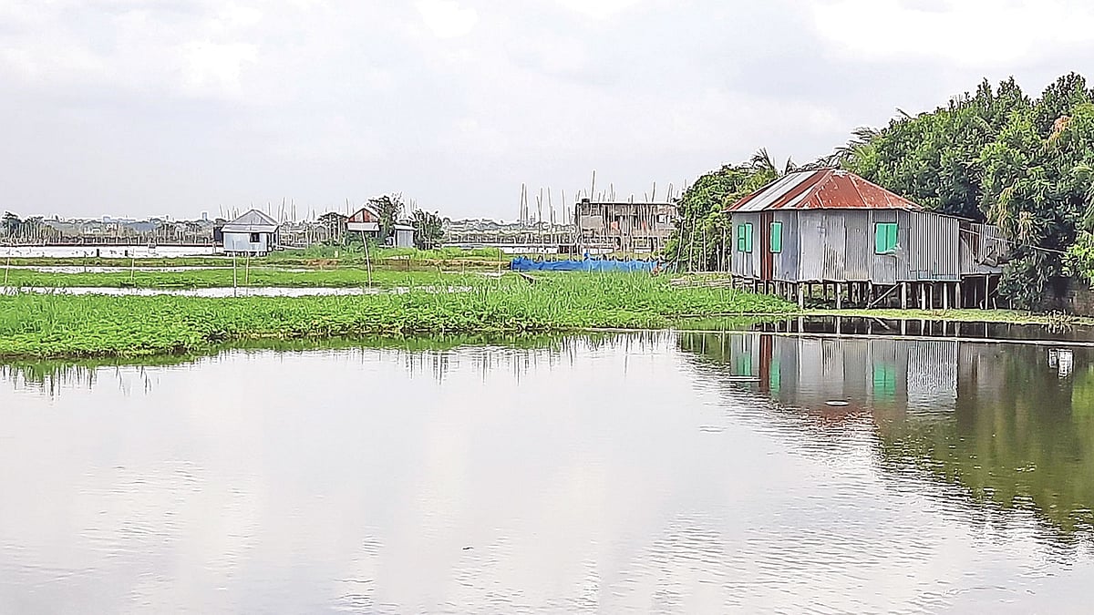 চারদিকে পানি। আটকে পড়া বাসিন্দারা চলাচল করছেন নৌকায় করে। গতকাল দুপুরে রাজধানীর খিলগাঁও থানার টেকপাড়া এলাকায়। ছবি: প্রথম আলো