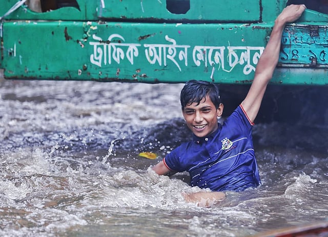 বৃষ্টিতে সড়কে পানি জমে গেছে। সেই পানিতে দুরন্তপনায় মেতেছে এক কিশোর। দয়াগঞ্জ, ঢাকা, ২১ জুলাই। ছবি: দীপু মালাকার