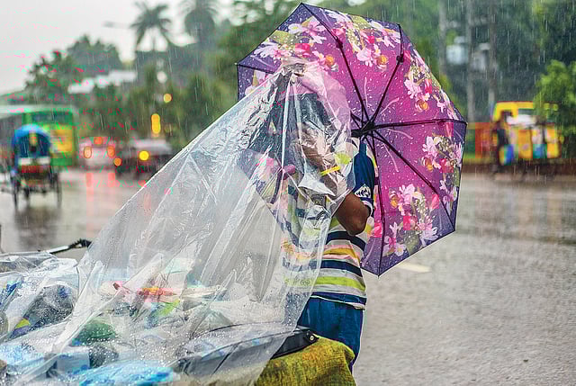 করোনাকালের বর্ষা-বৃষ্টির তোড় থেকে বাঁচতে পলিথিন দিয়ে নিজের মাস্ক ও হ্যান্ড স্যানিটাইজার রক্ষায় ব্যস্ত এক বিক্রেতা, ২১ জুলাই, ধানমন্ডি, ঢাকা। ছবি: আবীর আবদুল্লাহ