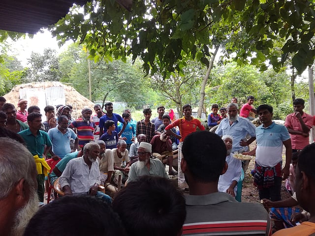পবার হরিপুর ইউনিয়নের চর মাঝারদিয়াড়ে রাস্তার সমস্যা মেটাতে চলছে সালিস। কারও মুখে মাস্ক নেই। যেন নির্ভয় এক জীবন কাটাচ্ছেন তাঁরা। ছবি: প্রথম আলো, রাজশাহী