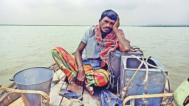 দুধের দাম পাচ্ছেন না। তাই হতাশা আর উৎকণ্ঠায় দুধের ব্যাপারী শহীদুল ইসলাম। সম্প্রতি পদ্মার চরের গ্রাম খিদিরপুর থেকে দুধ নিয়ে শহরে যাওয়ার পথে।  ছবি: প্রথম আলো