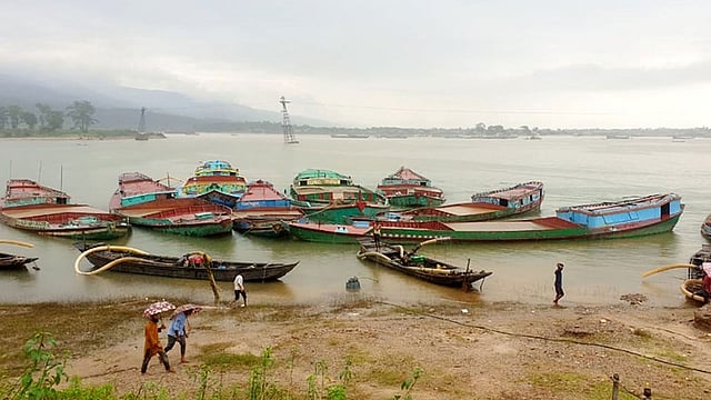 পাহাড়ি ঢল থেকে ধলাই নদে বড় বড় নৌকায় অবৈধভাবে তোলা হয় বালু ও পাথর। ২৭ জুলাই। ছবি: প্রথম আলো
