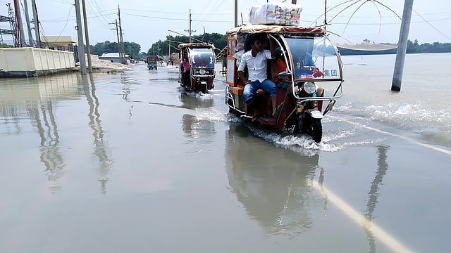 বন্যার পানির স্রোত জামালপুর-মাদারগঞ্জ সড়কের ওপর দিয়ে ব্যয়ে যাচ্ছে। মেলান্দহ উপজেলার ব্রাহ্মণপাড়া গ্রামে। ছবি: প্রথম আলো