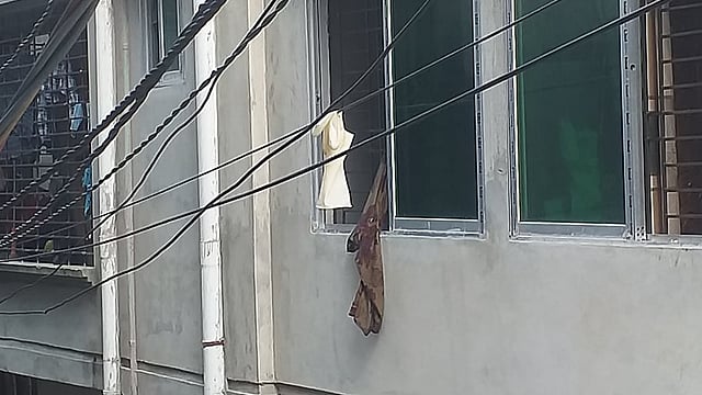 কোনো একটি বাড়ি থেকে ফেলা হয়েছে ব্যবহৃত গ্লাভস। সেটি বৈদ্যুতিক তারে আটকে ঝুলে আছে। করোনাকালে ব্যবহৃত গ্লাভস যেখানে-সেখানে ফেলায় স্বাস্থ্যঝুঁকি তৈরি হচ্ছে। আগারগাঁও এলাকা, ঢাকা, সাম্প্রতিক ছবি। ছবি: শাকিলা হক