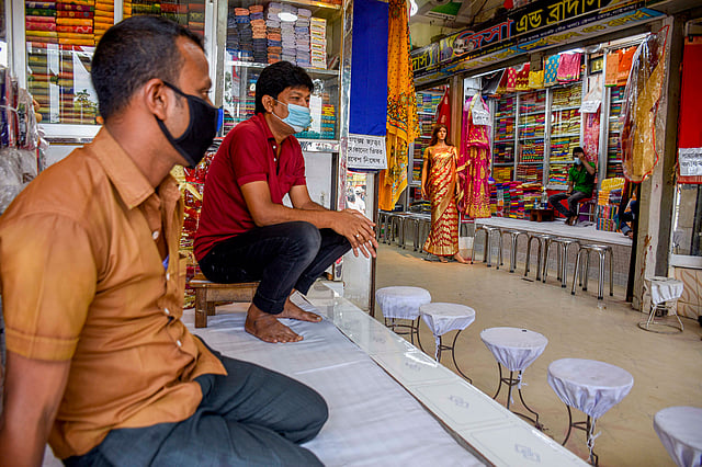 দোকান খুলে বসে আছেন। কিন্তু ক্রেতা নেই। ১৩ জুলাই গাইবান্ধা শহরের পৌর মার্কেট থেকে। ছবি: প্রথম আলো