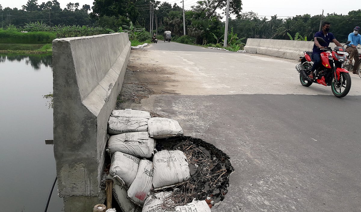 রাজবাড়ী-মধুখালী সড়কের সদর উপজেলার মাটিপাড়া সেতুর সংযোগ সড়ক ধসে গেছে। এতে দুর্ঘটনার আশঙ্কা করা হচ্ছে। ছবি: প্রথম আলো