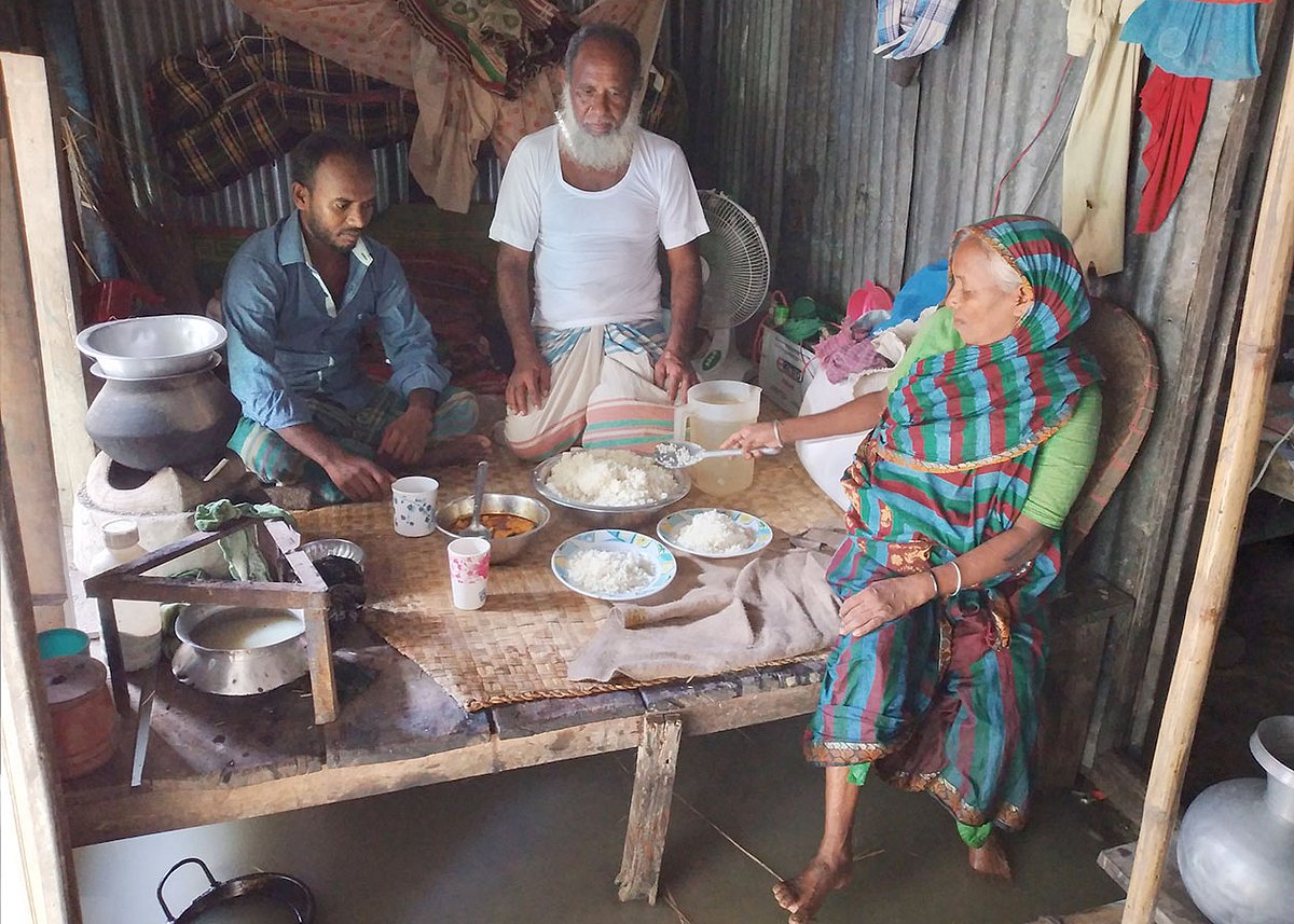 মোতালেব খানের বাড়িতে এ বছর ঈদের কোনো আয়োজন নেই। বাড়িতে যা রান্না হয়েছে, পরিবারের সদস্যদের নিয়ে তা–ই খেতে বসেছেন। আজ শনিবার সকালে নড়িয়ার মোক্তারের চর এলাকায়। ছবি: প্রথম আলো