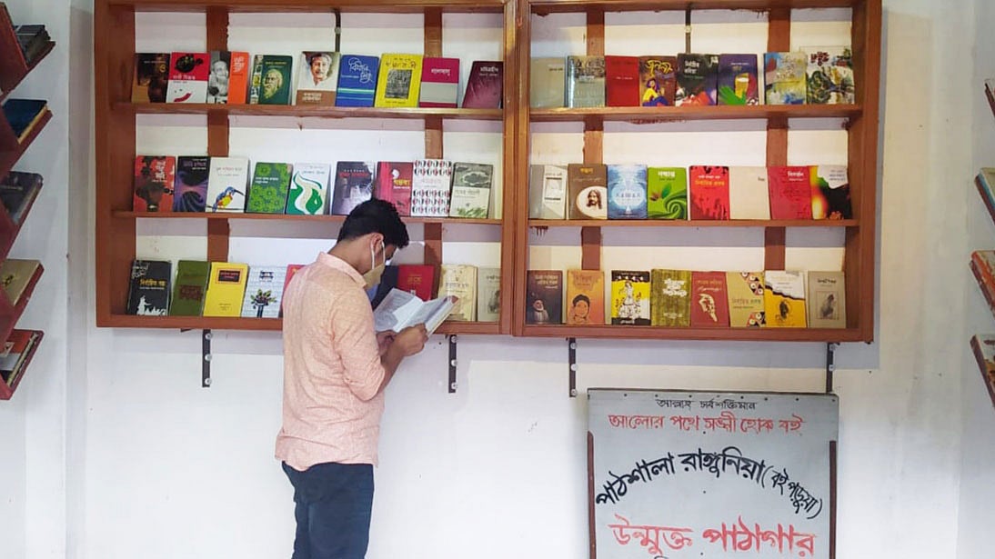 ‘পাঠশালা রাঙ্গুনিয়া উন্মুক্ত পাঠাগার’ এ বই দেখছেন এক তরুণ পাঠক। ছবি: প্রথম আলো