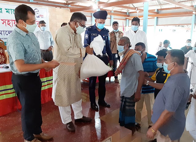 মানিকগঞ্জ সদর উপজেলার গড়পাড়া এলাকায় আজ সোমবার বন্যার্তদের মাঝে ত্রাণ সহায়তা দেন স্বাস্থ্যমন্ত্রী জাহিদ মালেক। ছবি: প্রথম আলো