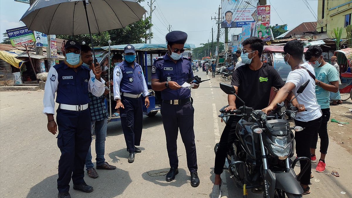 করোনা পরিস্থিতির কারণে দায়িত্ব বেড়ে গেছে পুলিশ সদস্যদের। মঙ্গলবার সকালে শরীয়তপুর জেলা শহরের রাজগঞ্জ ব্রিজ এলাকায়। ছবি: প্রথম আলো