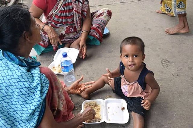 নারায়ণগঞ্জ শহরের স্বেচ্ছাসেবক সংগঠন মুক্ততরীর ২ টাকায় হাসি কর্মসূচিতে খাবার পেয়ে মায়ের সঙ্গে ভাগ করে খাচ্ছে ছোট্ট পথশিশুটি। নারায়ণগঞ্জ, ৪ আগস্ট। ছবি: রাব্বি হাসান