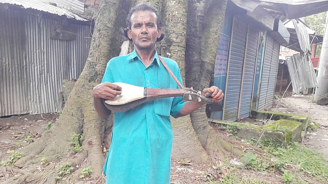 দোতারা হাতে পথের গায়ক নুরুল ইসলাম। করোনাভাইরাসের কারণে রোজগার নেই তাঁর। গতকাল শুক্রবার রাজশাহীর বাগমারা নীচা বাজার এলাকা থেকে ছবিটি তোলা। ছবি: প্রথম আলো
