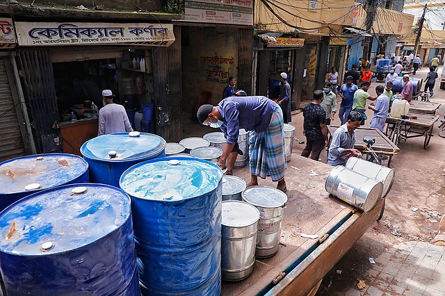 পুরান ঢাকার মিটফোর্ড রোড এলাকার একটি সরু গলিতে রাসায়নিক দ্রব্য নামানোর কাজ করছেন এক শ্রমিক। পুরান ঢাকার বাসিন্দারা বলছেন, তাঁরা রাসায়নিক দ্রব্যের সঙ্গে নয় বরং মৃত্যুকূপের মধ্যেই বসবাস করছেন। ২০১০ সালের নীমতলি ট্র্যাজেডি ও ২০১৯ সালে চুড়িহাট্টায় ভয়াবহ দুর্ঘটনার পর দাবি ওঠে, পুরান ঢাকার ঘিঞ্জি এলাকা থেকে এসব প্রাণঘাতী কেমিক্যাল কারখানা আর গুদাম সরিয়ে নেওয়ার। আরমানিটোলা স্ট্রিট, ঢাকা, ১০ আগস্ট। ছবি: দীপু মালাকার